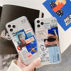 two clear cases with stickers on them are held up by someone's hand