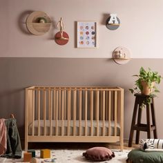 a baby's room with pink walls and wooden furniture