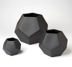 three black vases sitting next to each other