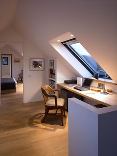 an attic bedroom with a desk and chair