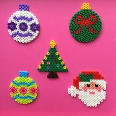 christmas ornaments made out of perler beads on a pink background, including a santa claus ornament