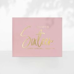 a pink and gold greeting card with the words suxter on it, against a white background