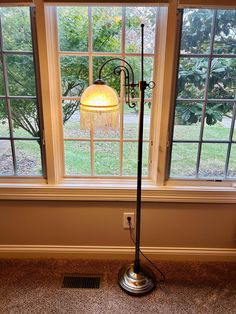 a floor lamp sitting in front of a window