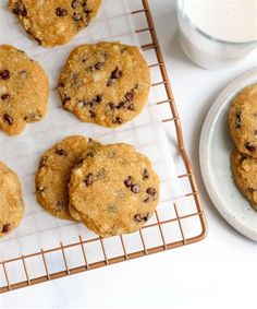 chocolate chip cookies cooling on a rack next to a glass of milk