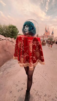 a woman in a red dress walking down a street