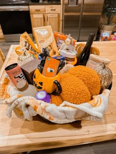 a basket filled with lots of different items on top of a wooden table in a kitchen