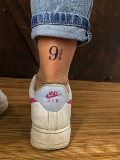 a woman's foot with a tattoo on her left ankle and the number nine