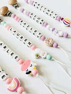 several pacifiers are arranged in rows on a white surface with the word baby spelled out