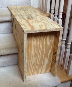 a wooden box sitting on top of a set of stairs next to a banister