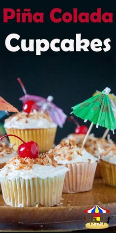 cupcakes topped with whipped cream and cherries are on a wooden platter