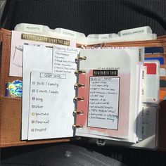 an open planner book sitting on top of a person's back seat in a car