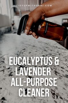 a person holding a bottle over a counter top with the words, eucalyptusptus & lavender all - purpose cleaner