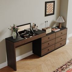 a desk with two drawers and a lamp on it in a living room next to a window