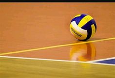 a volley ball sitting on top of a hard wood floor with the words love volleyball