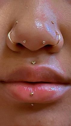 a woman's nose with two piercings on her nose and the bottom part of her nose