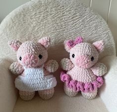 two small crocheted pigs sitting next to each other on a white chair together