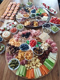 a platter filled with lots of different types of food on top of a wooden table