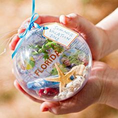 a hand holding a glass ornament with the name florida written on it,