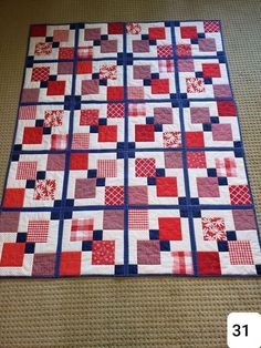 a red, white and blue quilt is laying on the floor