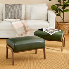 a living room with a white couch and green ottoman