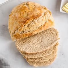 a loaf of bread sitting on top of a counter next to a bowl of butter