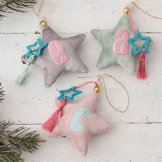 three star ornaments with numbers and tassels on them