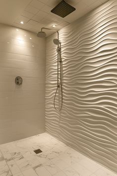 a bathroom with white tiles and a shower head in the corner, along with marble flooring