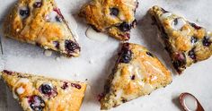 blueberry scones with white icing on a table