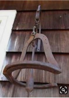 an old fashioned swing hanging from the side of a house