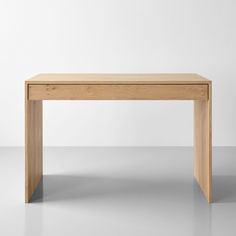 a wooden table sitting on top of a gray floor next to a white wall in an empty room