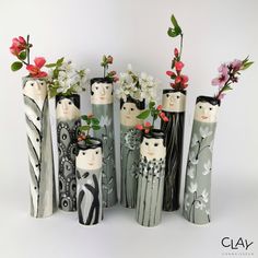 several vases with flowers in them sitting next to each other on a white surface