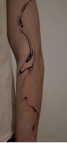 a man's arm with black ink on it and an abstract wave tattoo design