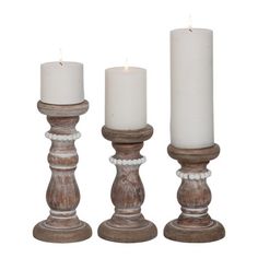 three white candles sitting next to each other