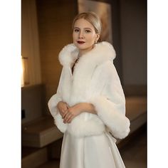 a woman in a white dress and fur coat