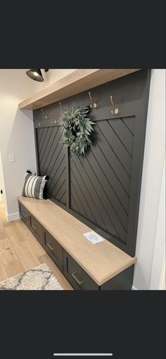 a wooden bench sitting in front of a wall with a wreath on top of it