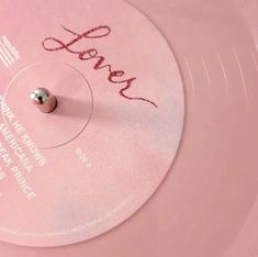 a pink record with the word love written on it's side and a small metal ball in the middle