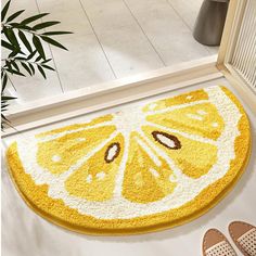 a yellow door mat with an orange slice cut in half