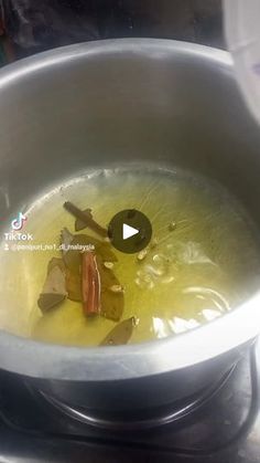 a metal bowl filled with liquid on top of a stove