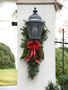 a street light decorated with christmas wreaths and pine cones