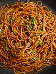 noodles with peas and sesame seeds in a wok