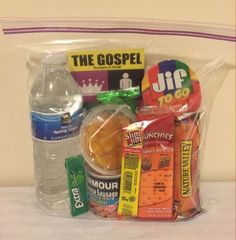 a plastic bag filled with different types of food and water bottles on top of a table