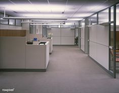 an empty office cubicle with desks and chairs