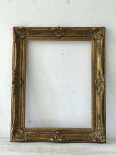 an old gold frame on a white wall