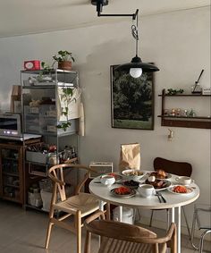 a dining room table with plates of food on it and two chairs in front of the table