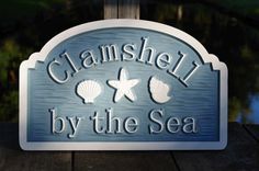 a wooden sign that says,'channel by the sea'with seashells and starfish on it