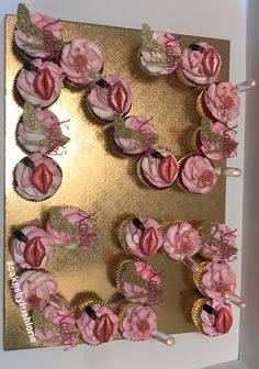 cupcakes are arranged in the shape of a heart on top of a gold plate