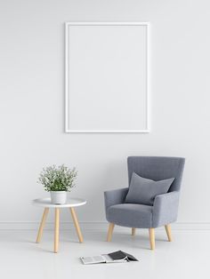 a chair and table in front of a white wall with a poster on the wall