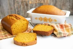 a loaf of pumpkin bread sitting on top of a table next to two pieces of bread