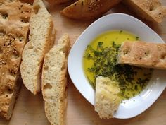 bread and butter are on a table next to a bowl of soup