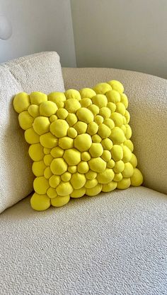 a yellow pillow sitting on top of a white couch